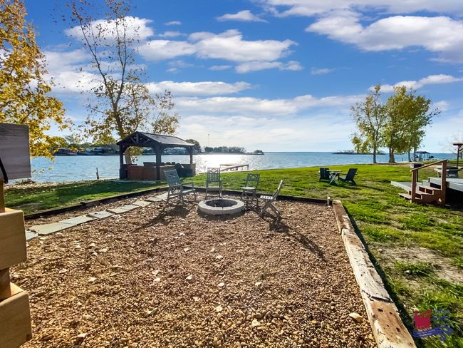 View of grassy yard with a gazebo, a water view, and a fire pit | Image 5