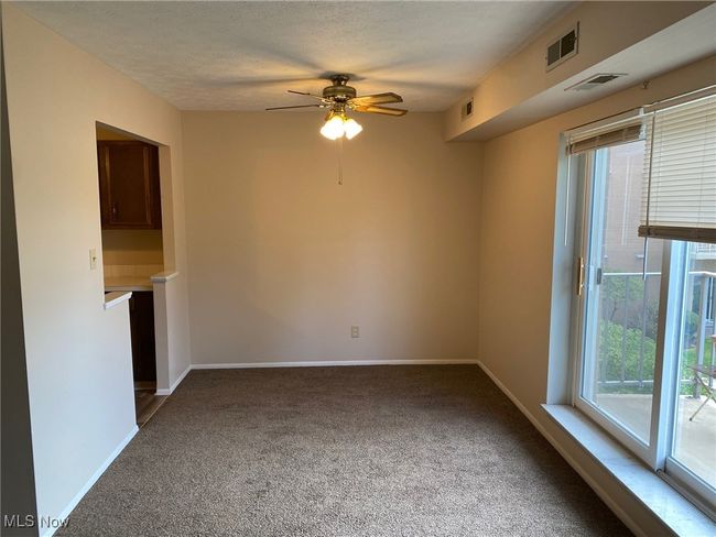 Unfurnished living room featuring plenty of natural light, visible vents, and carpet | Image 13