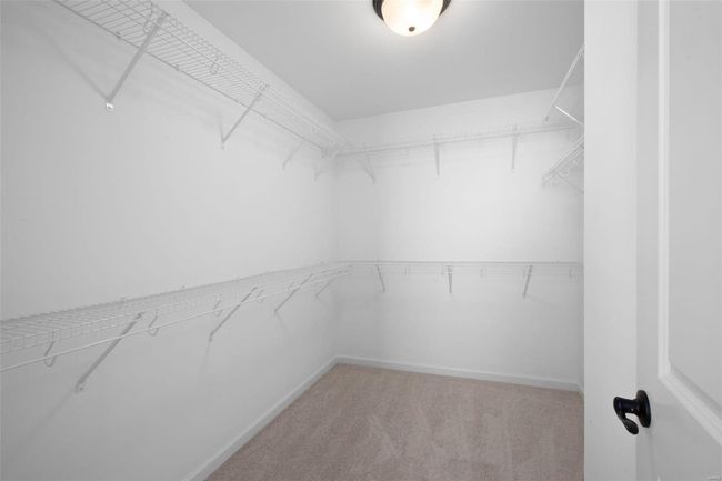 Walk in closet featuring light colored carpet | Image 28