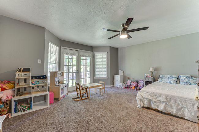 Bedroom with access to outside, carpet flooring, french doors, a textured ceiling, and a ceiling fan | Image 21