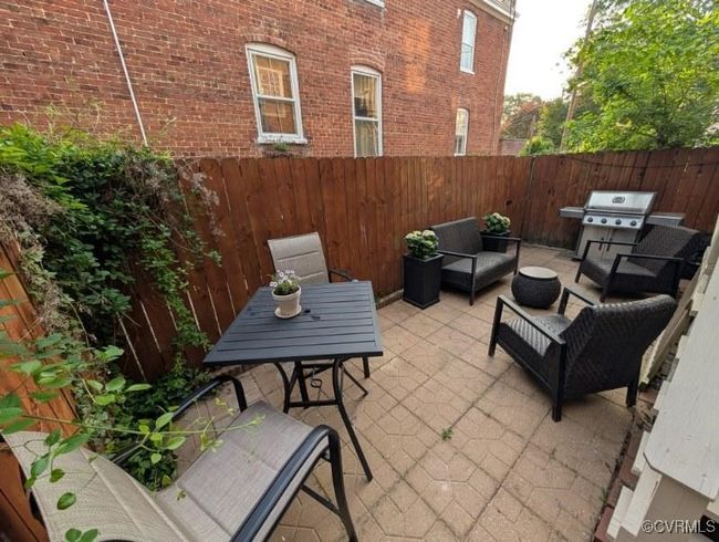 View of patio / terrace featuring a fenced backyard, an outdoor living space, and a grill | Image 35