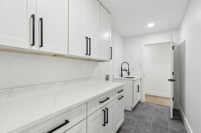 Amazing laundry area allows walk through access from main bedroom area or kitchen. Full size stackable laundry and sink with high end sprayer. | Image 28