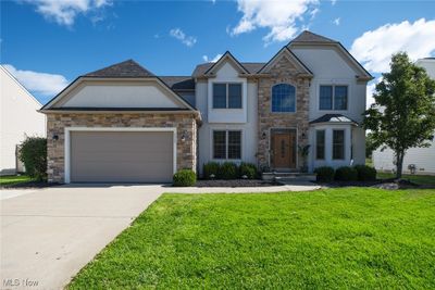 View of front facade featuring a front lawn and a garage | Image 1