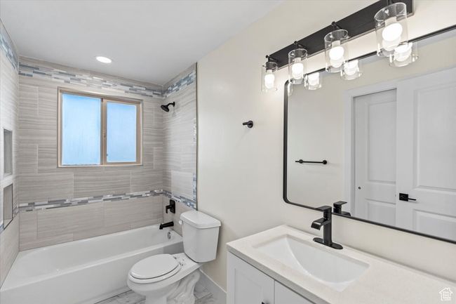 Full bath with toilet, vanity, shower combination, marble finish floor, and baseboards | Image 16