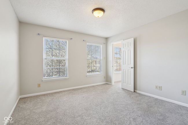 carpeted spare room featuring a textured ceiling and baseboards | Image 57