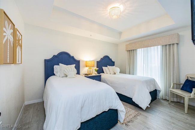 Guest Bedroom featuring two oversized twin beds, tray ceiling and wood-type flooring | Image 14