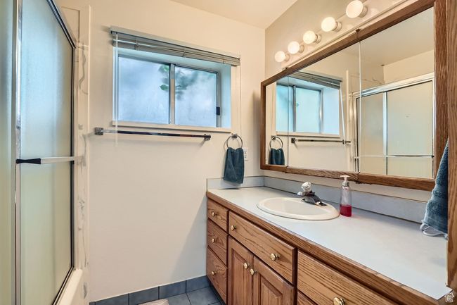 Full bathroom with a shower with shower door, vanity, and tile patterned floors | Image 25