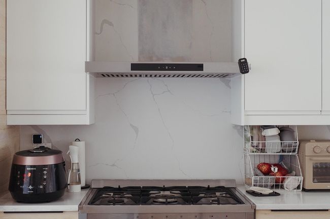 Kitchen with range hood, white cabinets, range, and light stone counters | Image 6