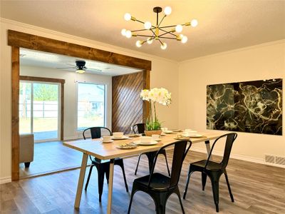 This open design living room and dining room are sure to impress any guests you have over. Notice the craftsman style wrapped beams | Image 2