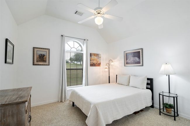 Carpeted bedroom with vaulted ceiling and a ceiling fan | Image 29