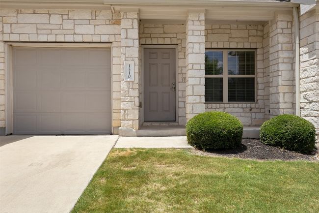 Entrance to property with concrete driveway and stone siding | Image 4