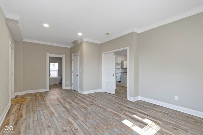 unfurnished bedroom featuring crown molding, wood finished floors, baseboards, and recessed lighting | Image 19