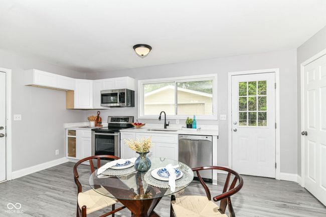 kitchen with appliances with stainless steel finishes, a sink, light countertops, and light wood-type flooring | Image 8
