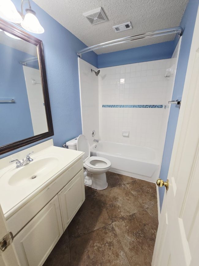 Full bathroom featuring vanity, toilet, shower combination, and a textured ceiling | Image 25