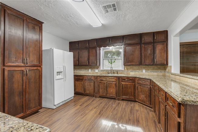 Kitchen featuring light granite countertops. | Image 9