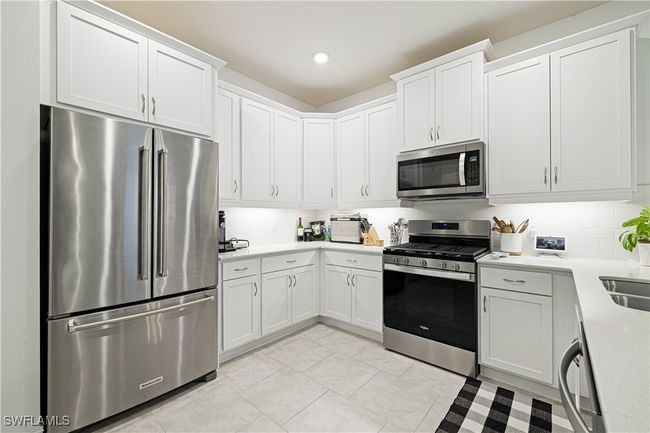 Kitchen featuring stainless steel appliances, light countertops, tasteful backsplash, white cabinetry, and recessed lighting | Image 14