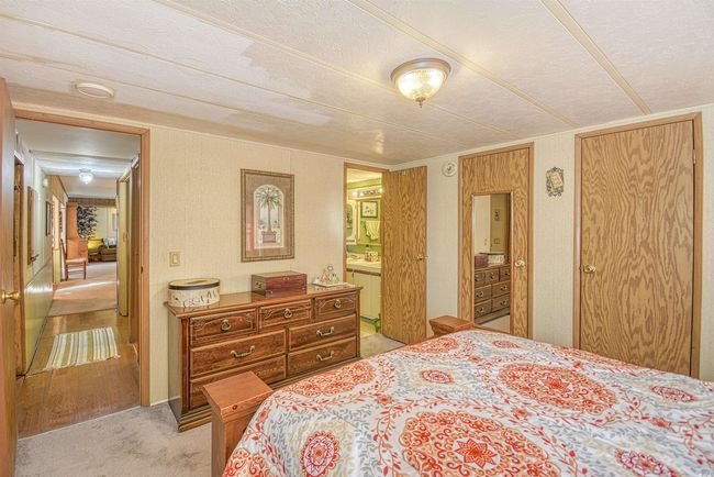 Bedroom with connected bathroom and light colored carpet | Image 17