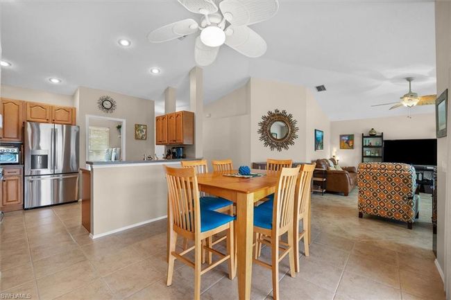Dining space featuring lofted ceiling, light tile patterned floors, ceiling fan, and recessed lighting | Image 16