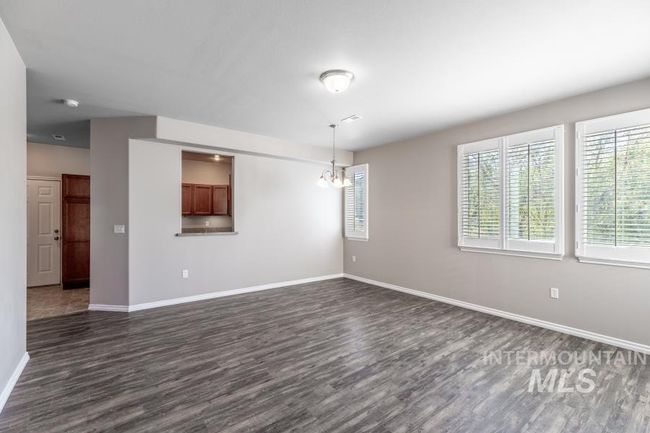 Unfurnished living room with dark wood-type flooring and a chandelier | Image 10