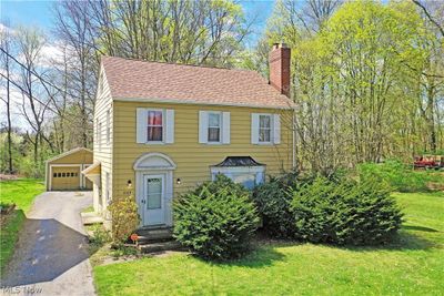 View of front facade featuring a front yard and a garage | Image 1