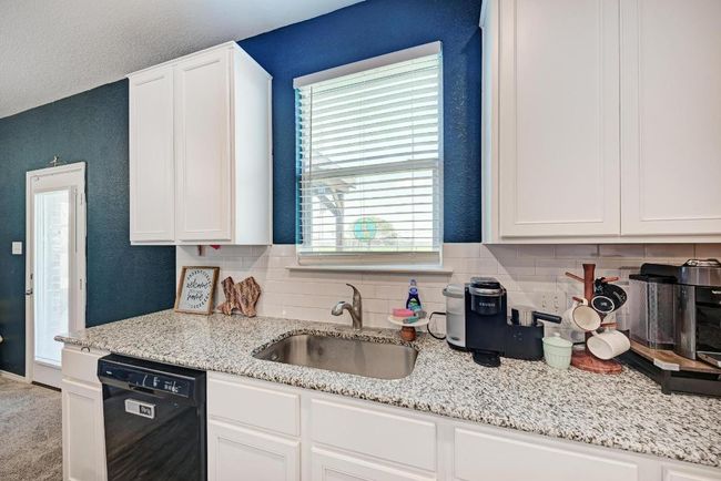 Kitchen with dishwasher, backsplash, and white cabinetry | Image 19