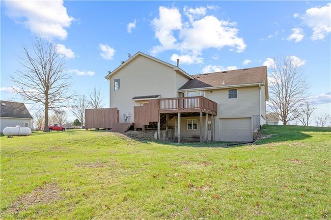Back of property featuring a yard, a wooden deck, and a garage | Image 12