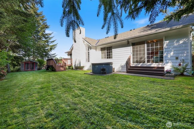Back yard view looking towards garden shed, hot tub and patio off primary bedroom. | Image 34