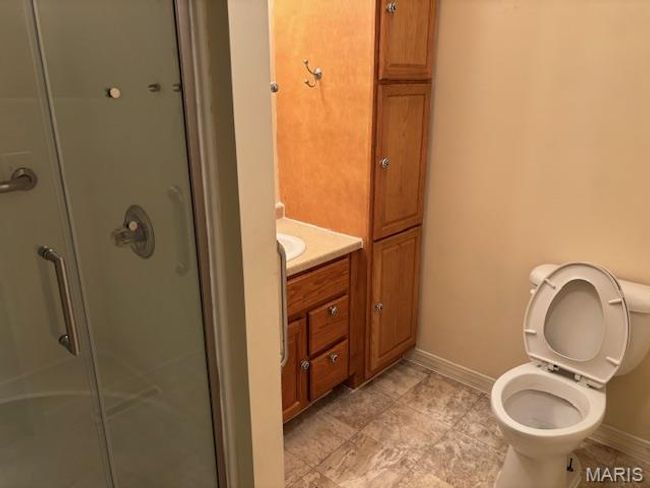 Full bath featuring a stall shower, baseboards, vanity, and toilet | Image 26