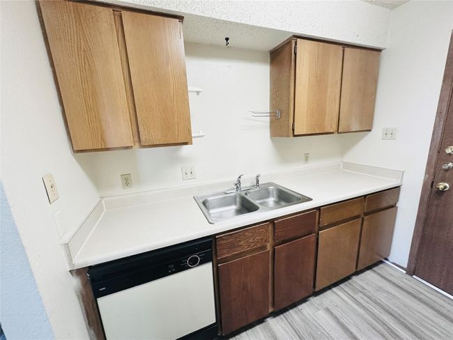 Kitchen with dishwasher, light countertops, and light wood-type flooring | Image 12