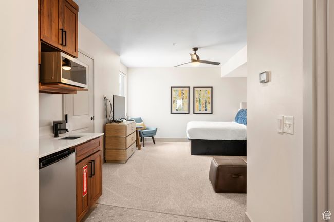 Bedroom featuring light carpet, a sink, and baseboards | Image 29