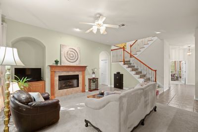 The cozy wood-burning fireplace serves as the centerpiece of the spacious family room. | Image 3