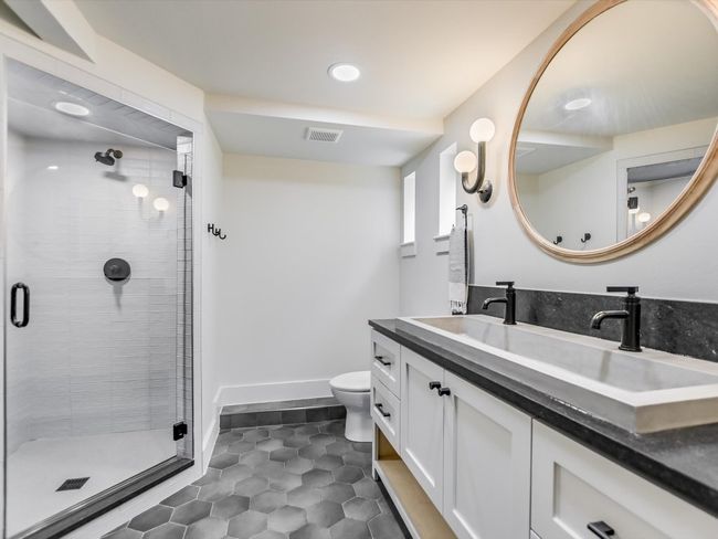Full bathroom featuring toilet, a stall shower, visible vents, and vanity | Image 17