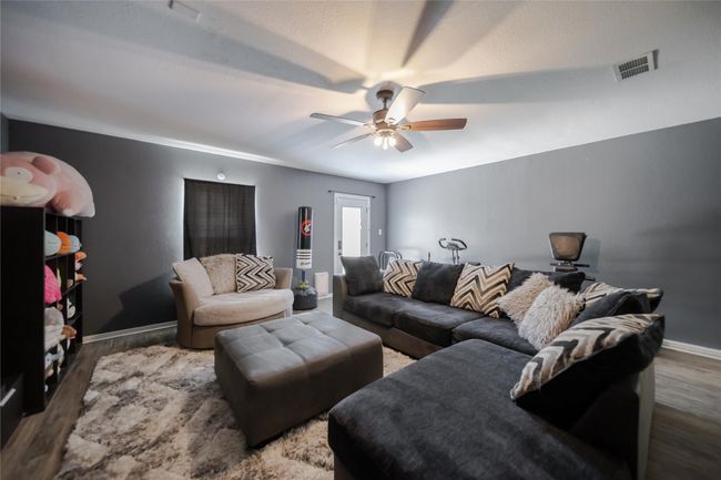 Living room with ceiling fan and wood finished floors | Image 16