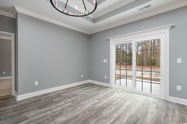 Empty room with hardwood / wood-style floors, a notable chandelier, and crown molding | Image 5
