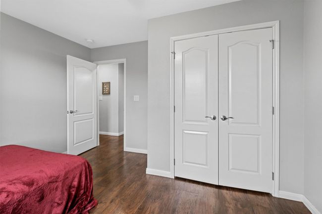 Bedroom with a closet, dark wood-type flooring, and baseboards | Image 30