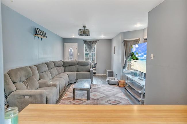 Living area with baseboards and wood finished floors | Image 6