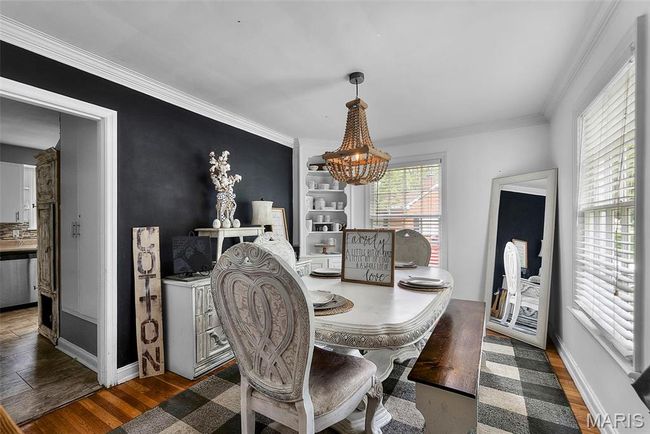 Dining room with a chandelier, wood finished floors, baseboards, and ornamental molding | Image 8