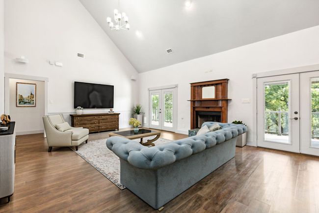 Living room featuring a chandelier, french doors, high vaulted ceiling, and dark wood-type flooring | Image 11
