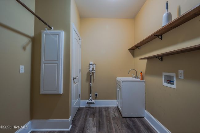 main level laundry room with sink and built-in ironing board | Image 46