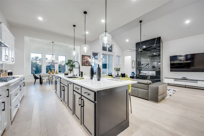 Enormous island with sink, light wood finished floors, and white cabinets | Image 7