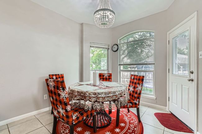 Dining space with a chandelier and light tile patterned flooring | Image 12