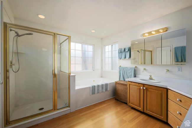 Bathroom with vanity, wood finished floors, recessed lighting, a bath, and a shower stall | Image 25