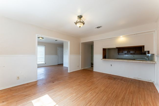 Unfurnished living room featuring visible vents, wainscoting, and light wood-style flooring | Image 4