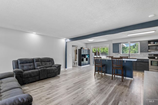 Living area with light wood-type flooring and a textured ceiling | Image 5