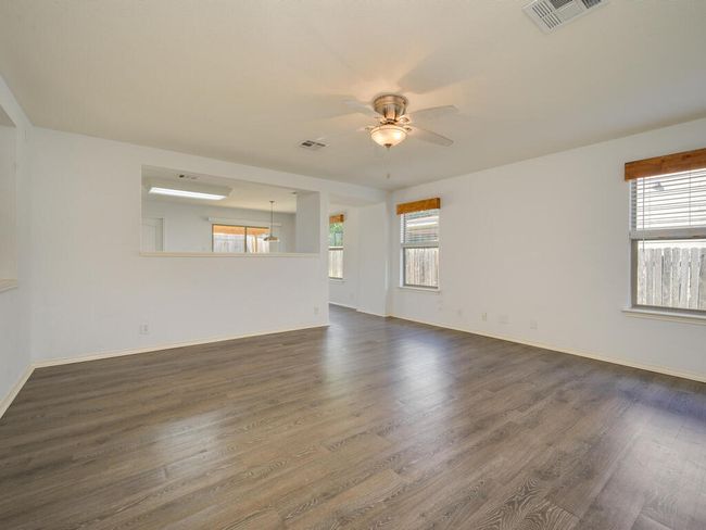 Living room with luxury vinyl wood look flooring and a ceiling​​‌​​​​‌​​‌‌​‌‌​​​‌‌​​‌‌​‌​​​​​‌ fan. | Image 5