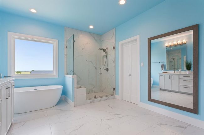 Full bath with marble finish floors, vanity, a marble finish shower, a freestanding bath, and baseboards | Image 26