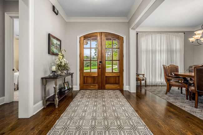 A beautiful entryway can set the tone for the entire home, and a wood double door entrance with hardwood floors certainly makes a striking first impression. As you step inside, the rich, natural tones of the wood create a warm & inviting atmosphere. | Image 29