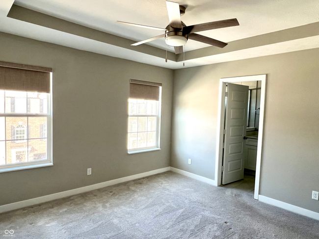 Primary bedroom with tray ceiling, custom blinds, ceiling fan & customized walk-in closet | Image 40