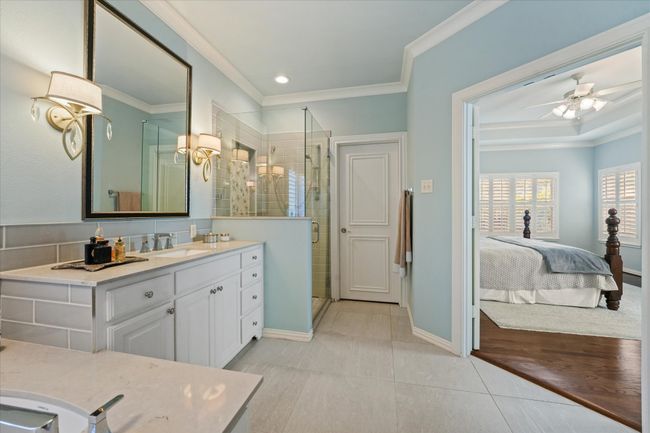 Full bath featuring vanity, crown molding, a shower stall, baseboards, and a ceiling fan | Image 25