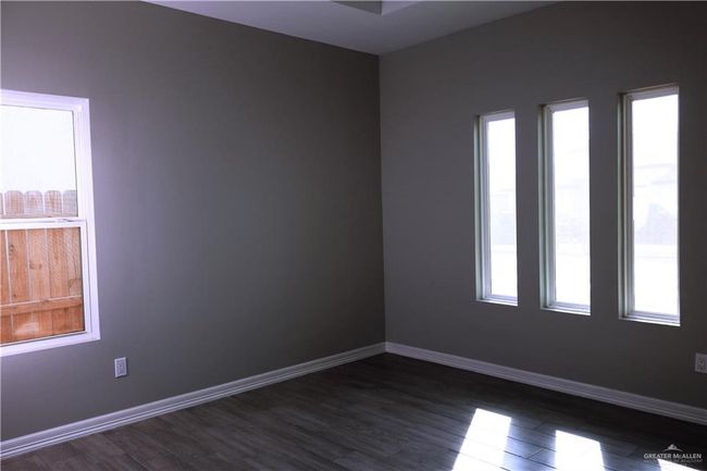 Unfurnished room featuring dark wood finished floors, baseboards, and a healthy amount of sunlight | Image 21